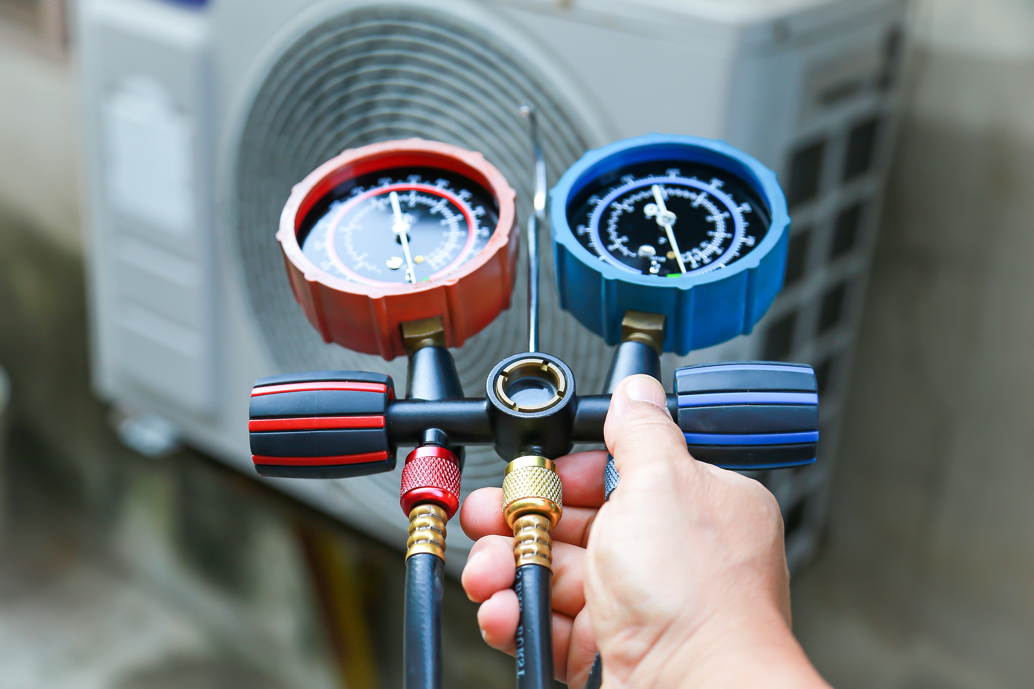 HVAC technician checking refrigerant levels with a pressure gauge